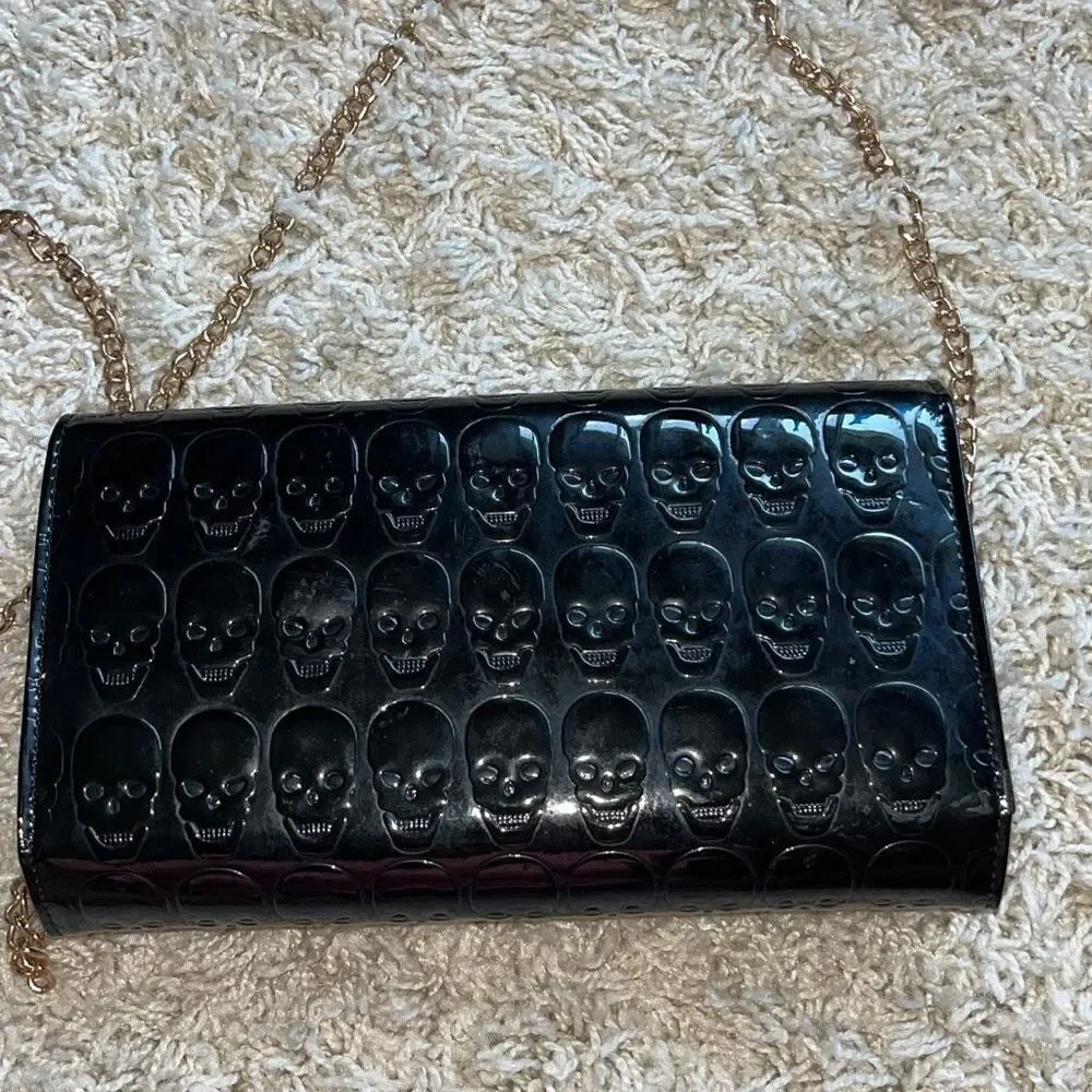 Awesome patent leather skull embossed clutch bag with gold chain shoulder strap.